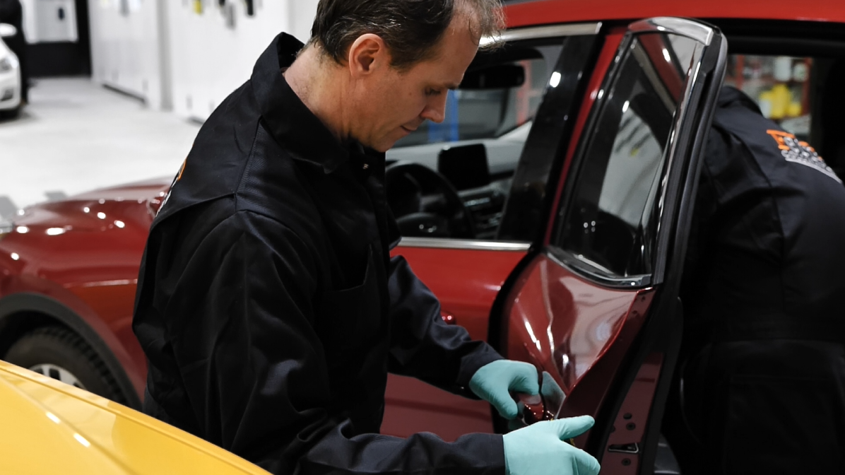 Ferreira Collision & Glass — technician working on door panel