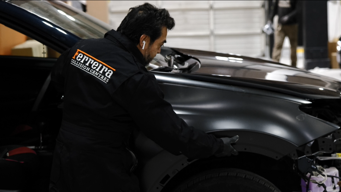 Ferreira Collision & Glass — technician fitting fender panel